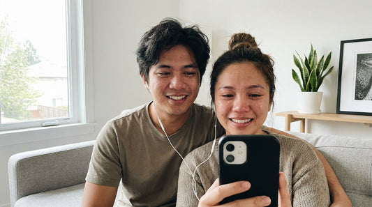 7.7 Sale gift guide from Gifty PH: a Filipino couple smiling while listening to a personalized song together on earphones in a modern home